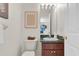 Bathroom featuring a toilet, a sink with green countertop and wooden vanity and decorative art at 11418 Tee Time Cir, New Port Richey, FL 34654