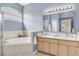 Relaxing bathroom with a soaking tub under an arched window, dual sinks, and soft blue walls at 11418 Tee Time Cir, New Port Richey, FL 34654