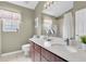 Bathroom featuring a window with curtains, a wooden vanity, white countertop, and a large mirror at 11418 Tee Time Cir, New Port Richey, FL 34654