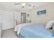 Bright bedroom with a ceiling fan, closet, and a comfortable metal-framed bed with blue bedding at 11418 Tee Time Cir, New Port Richey, FL 34654