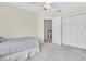 Bright bedroom with a ceiling fan, closet, and an open doorway to a second story landing at 11418 Tee Time Cir, New Port Richey, FL 34654