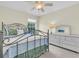 Comfortable bedroom with a wrought iron bed frame, matching dresser, and plenty of natural light at 11418 Tee Time Cir, New Port Richey, FL 34654