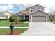 Charming home with a two-car garage, beautiful landscaping, and a well-manicured lawn on a sunny day at 11418 Tee Time Cir, New Port Richey, FL 34654