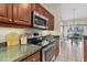 Kitchen counter space with granite countertops and stainless steel appliances adjacent to breakfast nook at 11418 Tee Time Cir, New Port Richey, FL 34654
