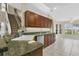 Bright kitchen with granite countertops, stainless steel sink, and tile floors next to stairs at 11418 Tee Time Cir, New Port Richey, FL 34654