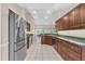 Spacious kitchen featuring stainless steel refrigerator, long countertops, and tile flooring at 11418 Tee Time Cir, New Port Richey, FL 34654