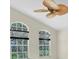 Bright loft features a ceiling fan and large arched windows offering outdoor views at 11418 Tee Time Cir, New Port Richey, FL 34654