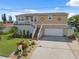 Two-story home with a front lawn and attached garage. An elevated porch adds architectural interest at 13027 Beacon Ct, Hudson, FL 34667