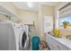 Well-lit laundry room with a washer, dryer, and ample counter space for folding at 13027 Beacon Ct, Hudson, FL 34667