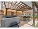 Outdoor entertainment space with a hot tub and an outdoor kitchen bar with seating for three under the covered patio at 13027 Beacon Ct, Hudson, FL 34667