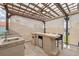 Outdoor bar area with built-in grill, sink, mini fridge, and bar seating is protected by a covered patio at 13027 Beacon Ct, Hudson, FL 34667
