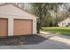 Exterior view of the two-car garage with black asphalt driveway of villa in Sugar Creek community at 13134 Cypress Hill Dr, Hudson, FL 34669