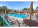 Community pool with lounge chairs, tables, and umbrellas offering a relaxing outdoor space at 13134 Cypress Hill Dr, Hudson, FL 34669