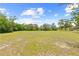 Expansive backyard featuring lush lawn and mature trees at 13180 Montour St, Brooksville, FL 34613