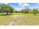 Large fenced backyard featuring ample open space, mature trees, and a storage shed at 13180 Montour St, Brooksville, FL 34613