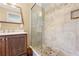 Well-lit bathroom with tiled shower, glass door, and dark wood vanity with marble countertop at 13180 Montour St, Brooksville, FL 34613