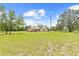 Sprawling single-story home with lush front lawn and mature trees on a sunny day at 13180 Montour St, Brooksville, FL 34613