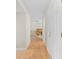Bright hallway featuring wood floors that leads to an open room with a desk and neutral color paint at 13180 Montour St, Brooksville, FL 34613