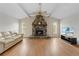 Inviting living room featuring a stone fireplace, ceiling fan, and hardwood floors at 13180 Montour St, Brooksville, FL 34613
