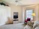 Bright bedroom with a ceiling fan, window, small television, and a floral patterned sofa at 13321 Norman Cir, Hudson, FL 34669