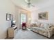 Carpeted bedroom features a ceiling fan, a window, floral print sofa, and a television at 13321 Norman Cir, Hudson, FL 34669