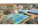 A high angle shot captures the community tennis courts, pool, and nearby residential housing at 13321 Norman Cir, Hudson, FL 34669