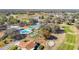 Aerial view of multiple community amenities including pool, tennis, and shuffleboard courts near residential homes at 13321 Norman Cir, Hudson, FL 34669