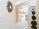 Inviting foyer with tile flooring leading to a bright kitchen featuring white cabinets at 13321 Norman Cir, Hudson, FL 34669