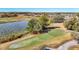 Panoramic view of a community golf course and pond surrounded by lush scenery and mature trees at 13321 Norman Cir, Hudson, FL 34669