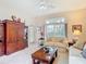 Inviting living room featuring a large cabinet, neutral carpet, and natural light from the backyard at 13321 Norman Cir, Hudson, FL 34669