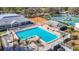 Aerial view of the community pool area with brick patio, clear blue water, and shaded seating at 13321 Norman Cir, Hudson, FL 34669
