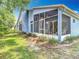A charming screened patio area for outdoor living is attached to this beautiful blue home at 13321 Norman Cir, Hudson, FL 34669