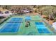 Aerial view of multiple tennis and pickleball courts showing the nets and surrounding fencing at 13321 Norman Cir, Hudson, FL 34669