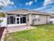 View of the house showing the screened in porch, brick patio, and grassy backyard at 14655 Potterton Cir, Hudson, FL 34667
