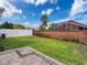 Spacious backyard featuring a brick-paved patio, lush green grass, and a sturdy fence for privacy at 14655 Potterton Cir, Hudson, FL 34667