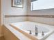 Close up of the soaking tub highlighting the tile work and chrome fixtures at 14655 Potterton Cir, Hudson, FL 34667