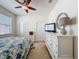 Bright bedroom features a ceiling fan, a window, and a dresser for storage at 14655 Potterton Cir, Hudson, FL 34667