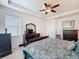 Bright bedroom showcasing a ceiling fan, dresser with a TV, and a luxurious patterned bedspread at 14655 Potterton Cir, Hudson, FL 34667