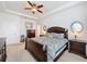 Spacious bedroom featuring a ceiling fan, tray ceiling, and dark wood furniture set at 14655 Potterton Cir, Hudson, FL 34667