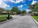 Gated community entrance with brick pillars, manicured landscaping, and a secure entry system at 14655 Potterton Cir, Hudson, FL 34667