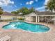 A refreshing community pool is surrounded by a fence, lounge chairs, and covered tables at 14655 Potterton Cir, Hudson, FL 34667