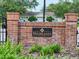 Brick community sign displays the neighborhood name surrounded by manicured landscaping at 14655 Potterton Cir, Hudson, FL 34667