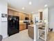 Galley kitchen features black appliances, granite countertops, breakfast bar, and tile flooring at 14655 Potterton Cir, Hudson, FL 34667