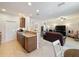 Open kitchen with breakfast bar flowing into living room; tile flooring and recessed lighting at 14655 Potterton Cir, Hudson, FL 34667