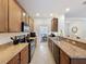 Well lit kitchen featuring stone countertops, stainless appliances, wooden cabinets and tile flooring at 14655 Potterton Cir, Hudson, FL 34667