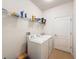 Laundry room featuring a white washer and dryer and shelving and door to right at 14655 Potterton Cir, Hudson, FL 34667