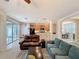 Bright living room with ceiling fan, kitchen view and sliding glass doors at 14655 Potterton Cir, Hudson, FL 34667