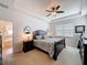 Main bedroom suite with tray ceilings, carpet flooring, ceiling fan, and adjoining en-suite bathroom at 14655 Potterton Cir, Hudson, FL 34667