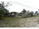 An exterior view of a large, overgrown backyard with a shed and a neighboring home at 1601 Dixie Hwy, Tarpon Springs, FL 34689