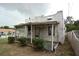 Exterior of a home featuring a covered porch with lattice trim and vintage details at 1601 Dixie Hwy, Tarpon Springs, FL 34689